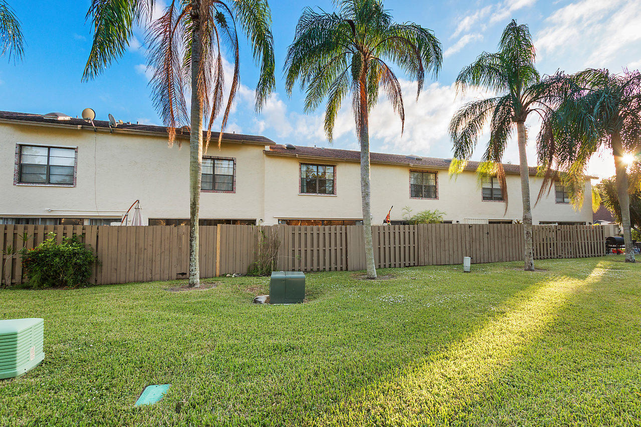 8815 Southwest 21st Street, Unit D Boca Raton, FL 33433 - Photo 23 of 27 a view of a house with a yard and palm trees