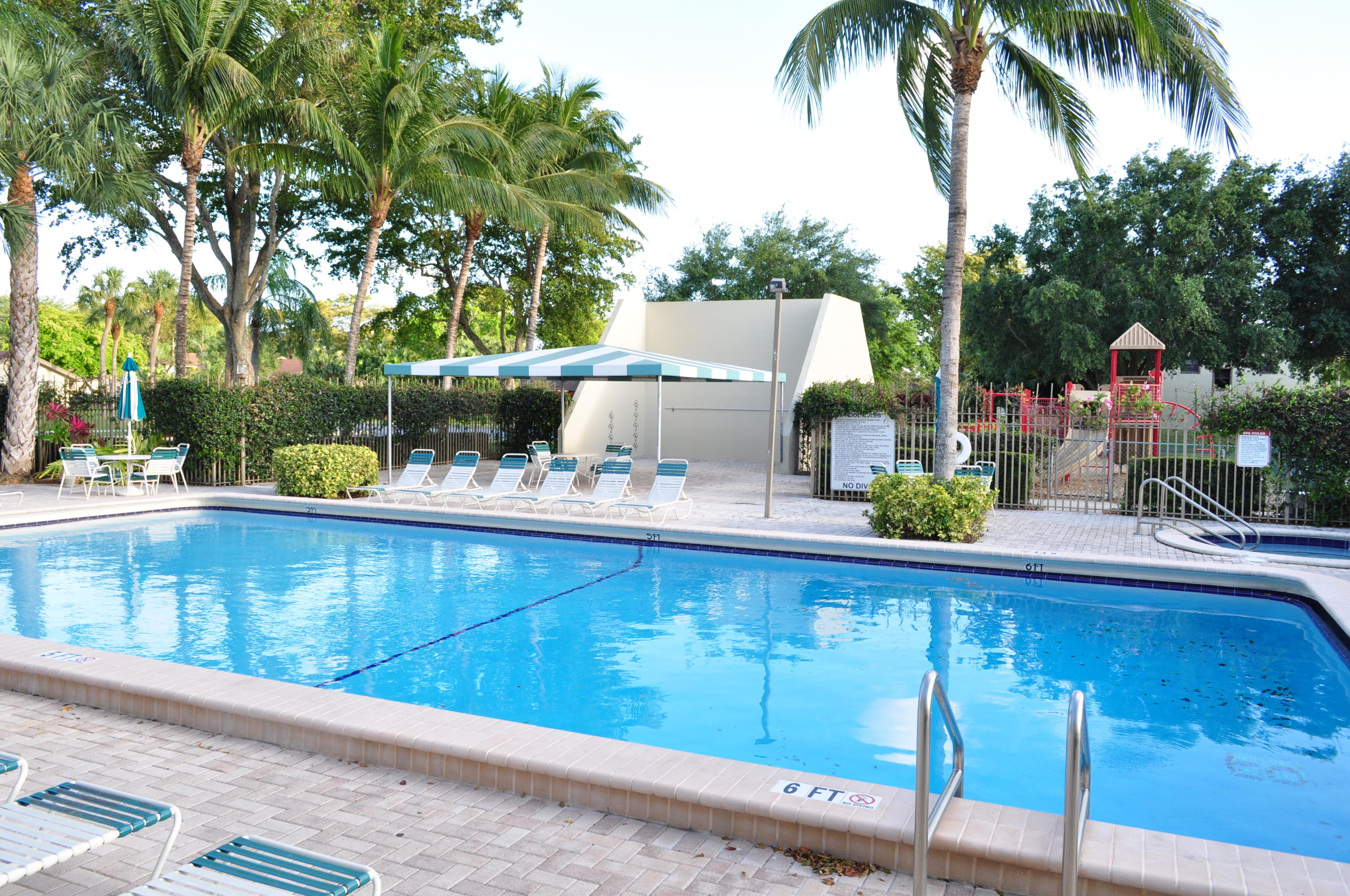 8815 Southwest 21st Street, Unit D Boca Raton, FL 33433 - Photo 27 of 27 a view of swimming pool with a bench and trees around