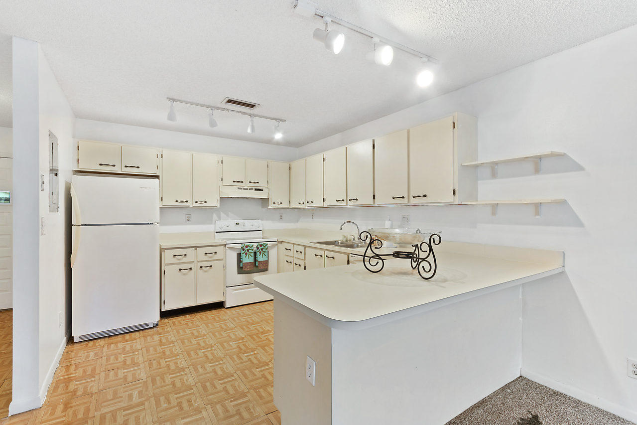 8815 Southwest 21st Street, Unit D Boca Raton, FL 33433 - Photo 8 of 27 a kitchen with a refrigerator a sink and a stove top oven