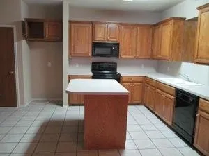 a kitchen with kitchen island granite countertop a stove a sink and a refrigerator