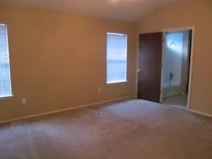 an empty room with windows and closet