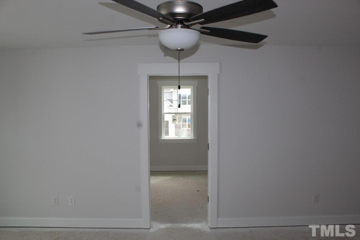 320 Prides Crossing Rolesville, NC 27571 - Photo 15 of 23 a view of wooden floor and a chandelier fan in a room