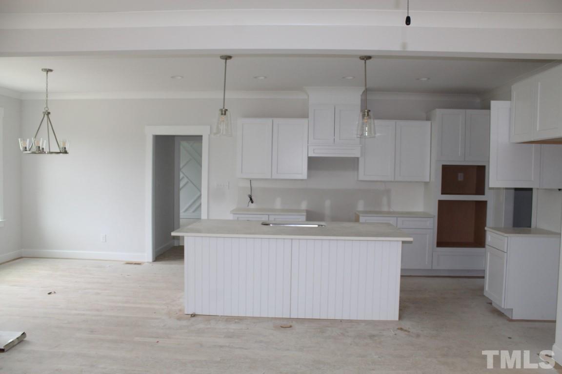 320 Prides Crossing Rolesville, NC 27571 - Photo 2 of 23 a kitchen with kitchen island a sink stainless steel appliances and cabinets