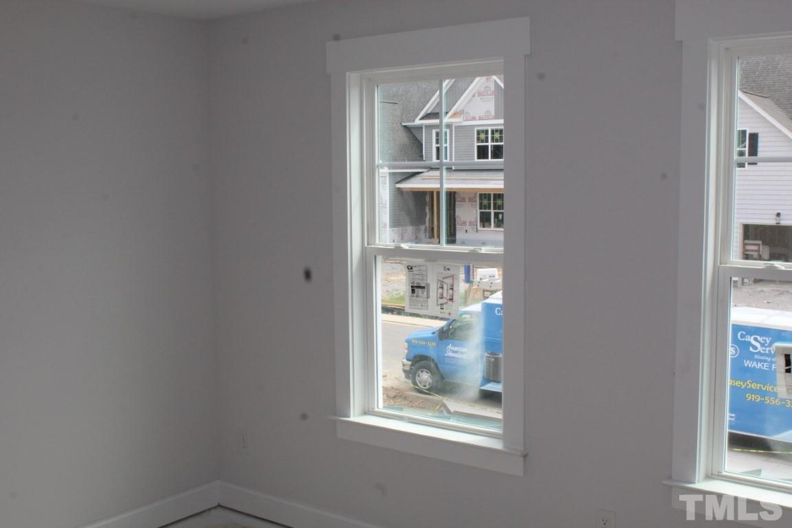 320 Prides Crossing Rolesville, NC 27571 - Photo 10 of 23 an empty room with kitchen view and wooden floor