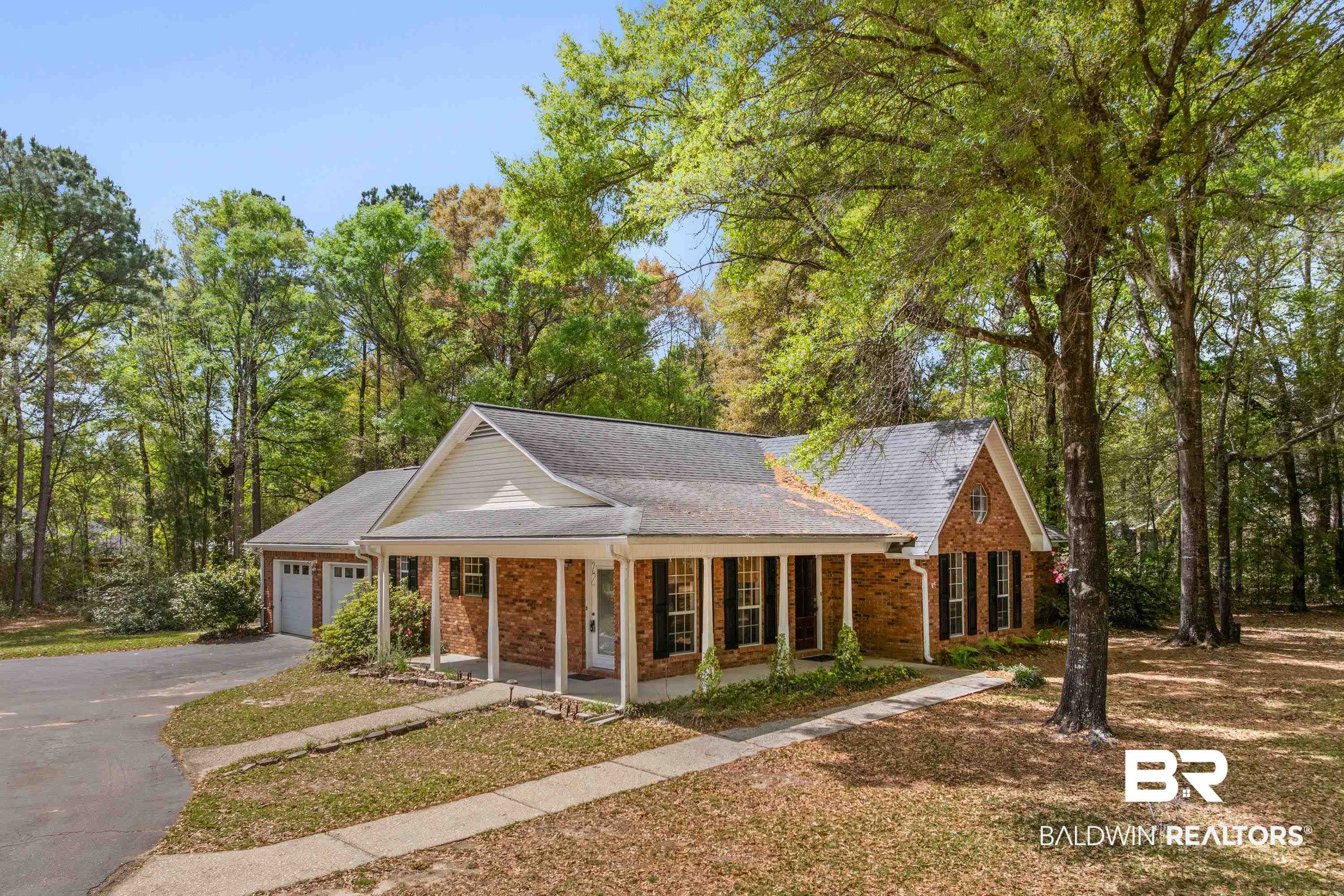 10140 Lakeview Road Bay Minette, AL 36507 - Photo 24 of 35 View of front of house featuring a porch, brick siding, a garage, asphalt driveway, and a front lawn