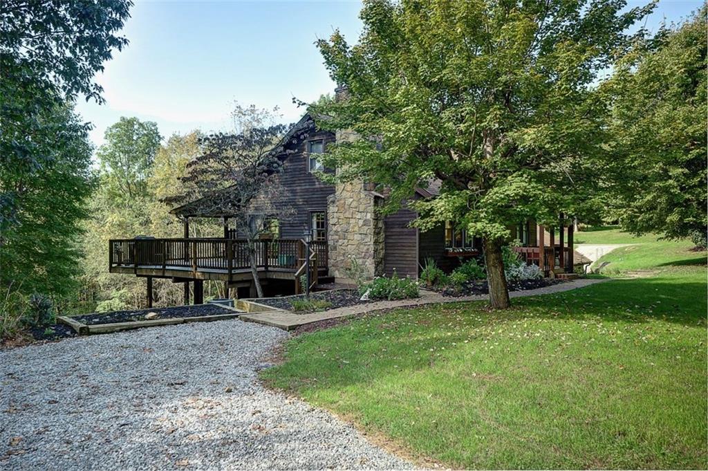 130 Ridgeview Lane Harmony, PA 16037 - Photo 2 of 24 LARGE corner elevated deck, open & covered sections, overlook the separate fire pit area, sweeping back lawn which flows into the woodlands. Covered front porch with room for 4.