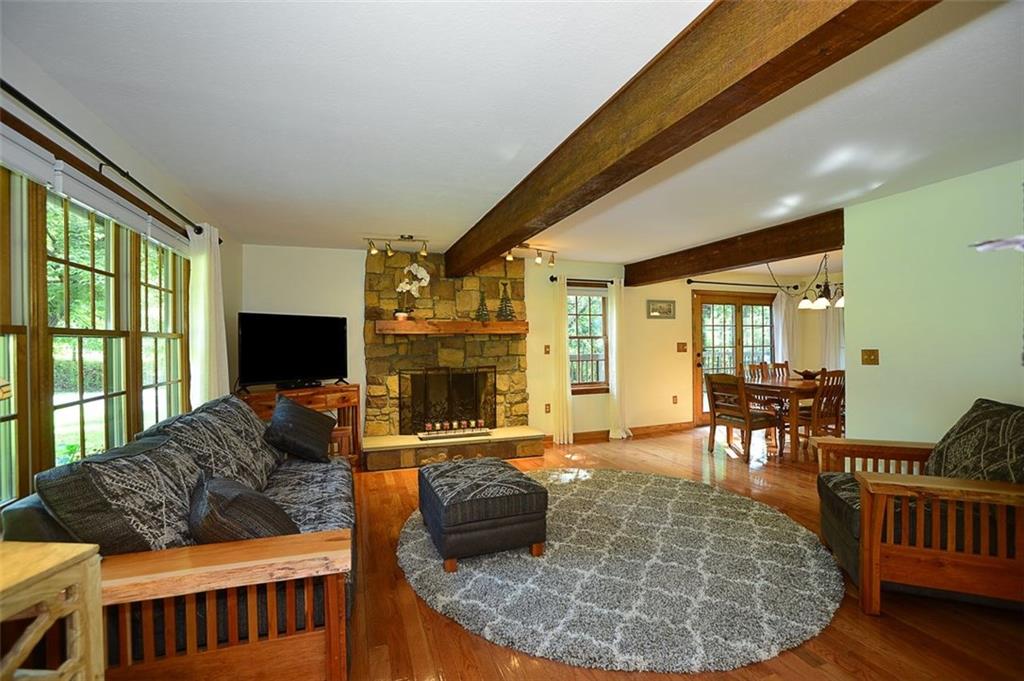 130 Ridgeview Lane Harmony, PA 16037 - Photo 7 of 24 Living room features natural wood-beamed ceiling & stone-faced, wood burning Fireplace & PLENTY of windows keep this area bright & cheery! Real Oak floor.
