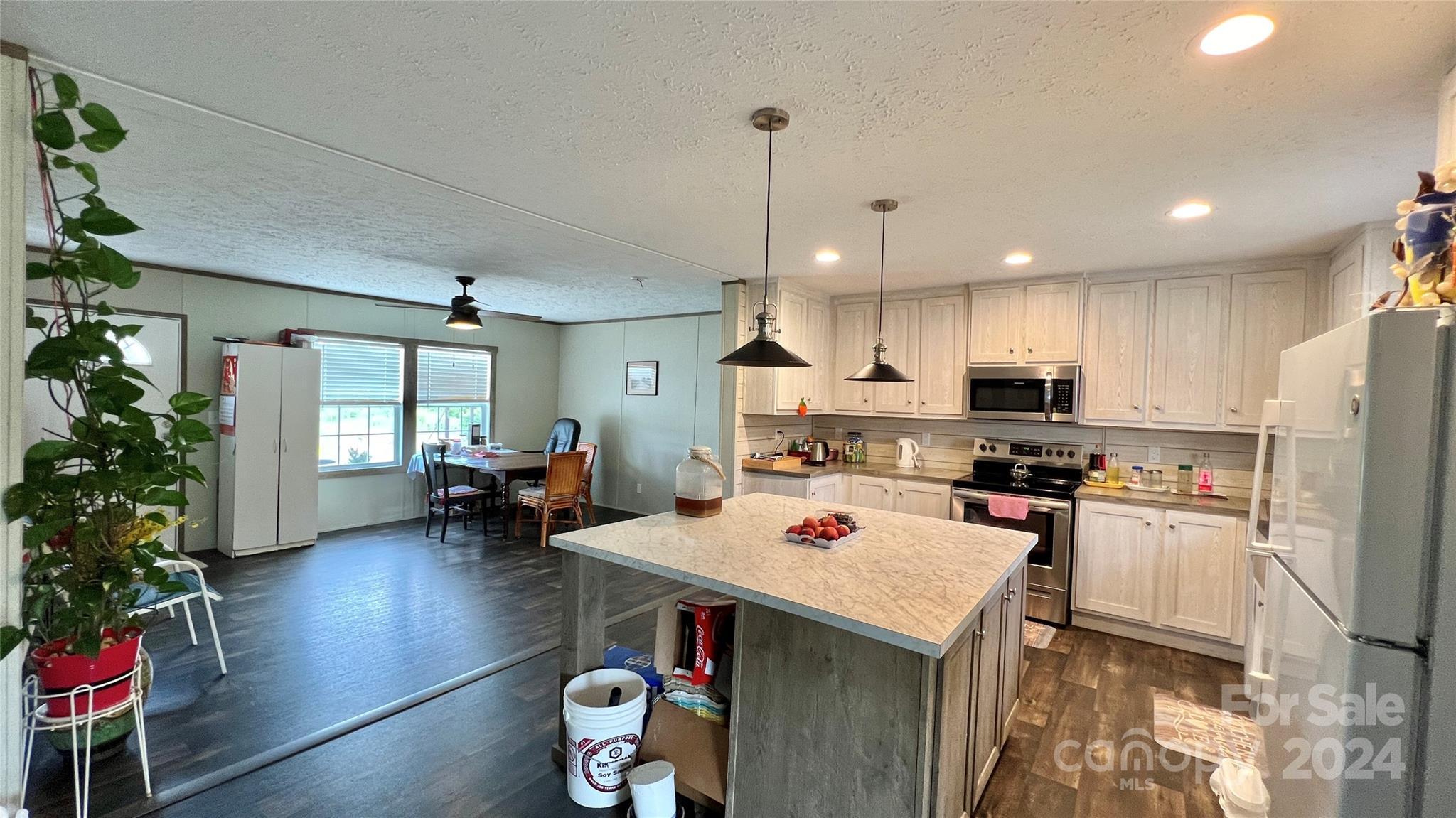 1824 Germantown Place Dillon, SC 29536 - Photo 3 of 16 a kitchen with a refrigerator a stove and a dining table with wooden floor