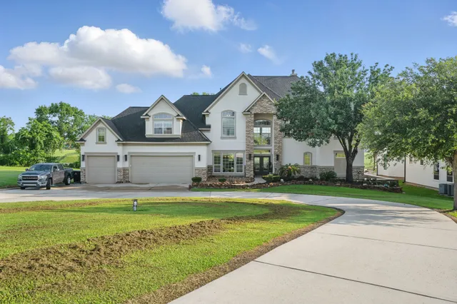 a view of a house with a big yard and large trees