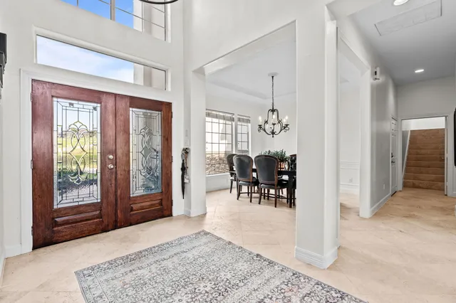 a living room with furniture a large window and a chandelier