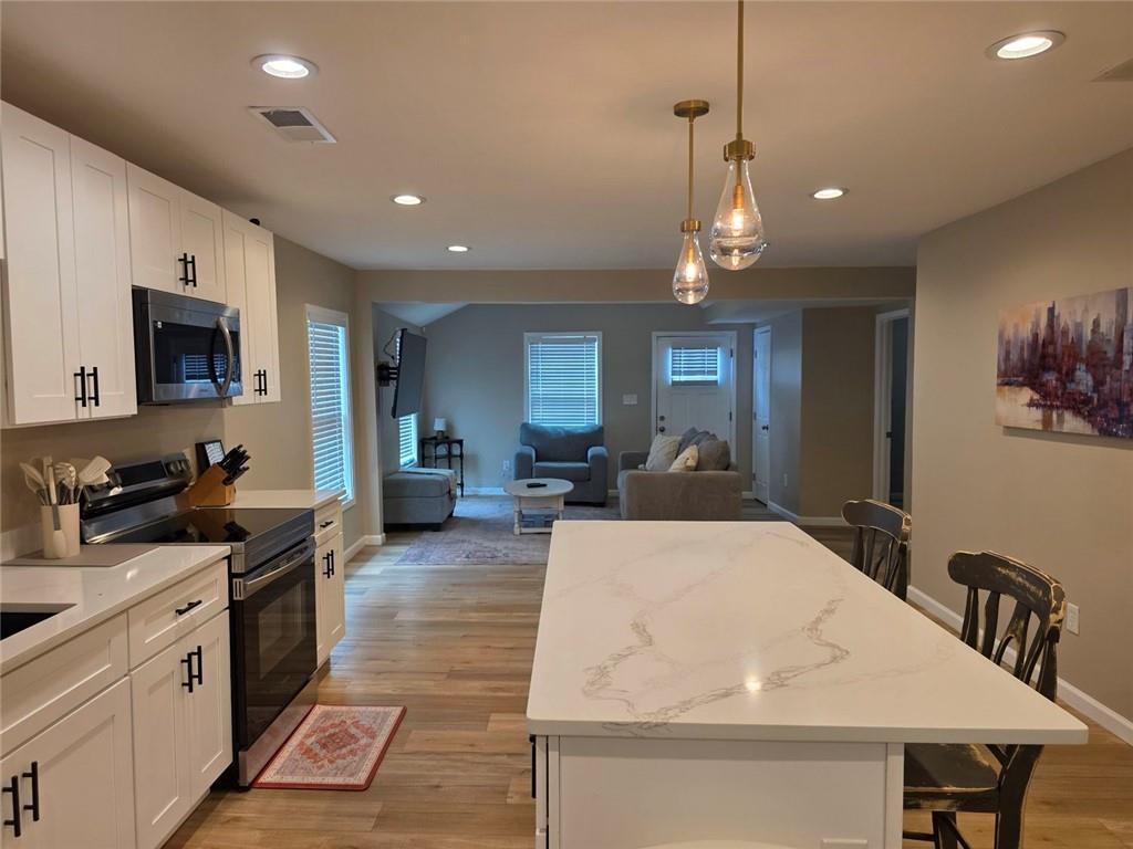722 Lacy Street Monroe, GA 30655 - Photo 8 of 19 a large kitchen with kitchen island a large counter space a sink appliances and cabinets