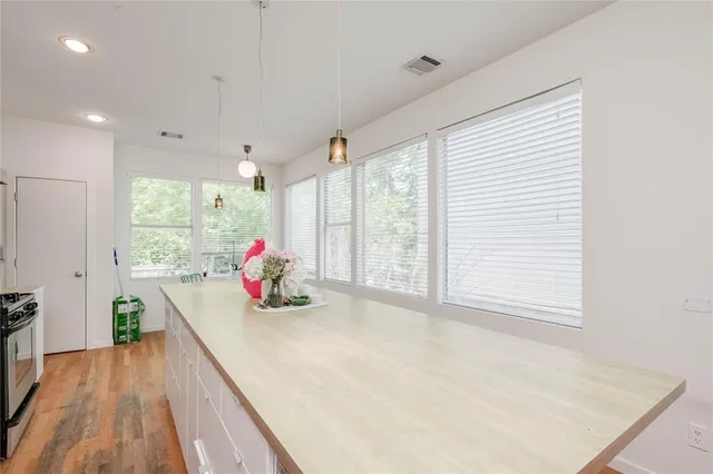 a kitchen with stainless steel appliances kitchen island granite countertop a stove a sink and a refrigerator