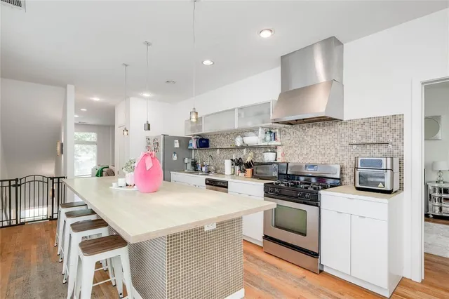 a kitchen with granite countertop a stove and a wooden floor