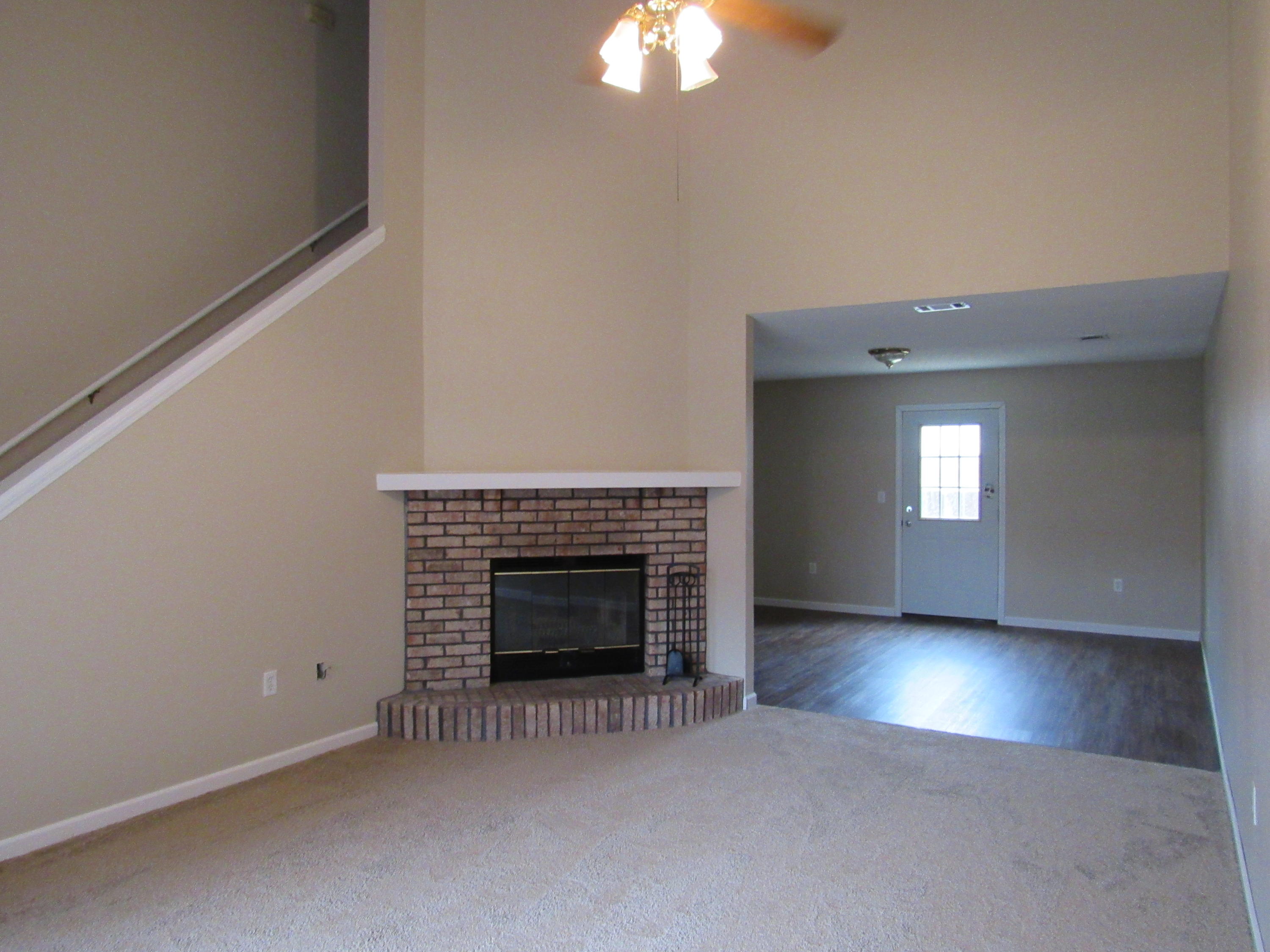 713 Valley Road Crestview, FL 32539 - Photo 2 of 17 an empty room with a fireplace and chandelier fan