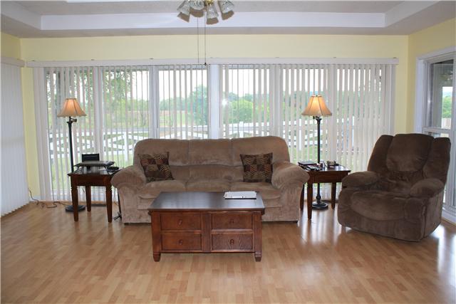 322 Long Road Ardmore, TN 38449 - Photo 8 of 20 Den - With trey ceiling and laminate flooring plus floor to ceiling windows with vertical blinds for lots of natural light and great views of the acreage.