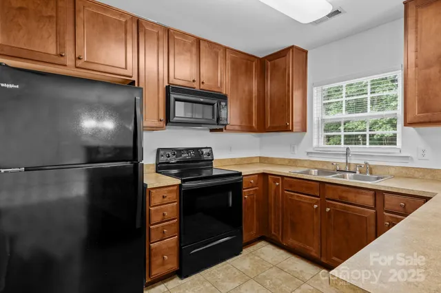 a kitchen with stainless steel appliances granite countertop a stove a refrigerator and a sink