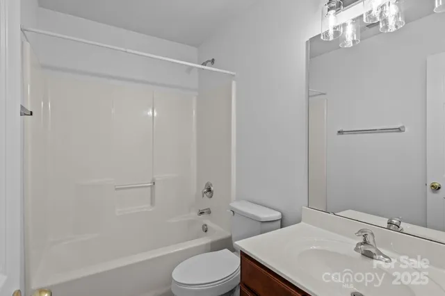 a bathroom with a sink toilet vanity and shower