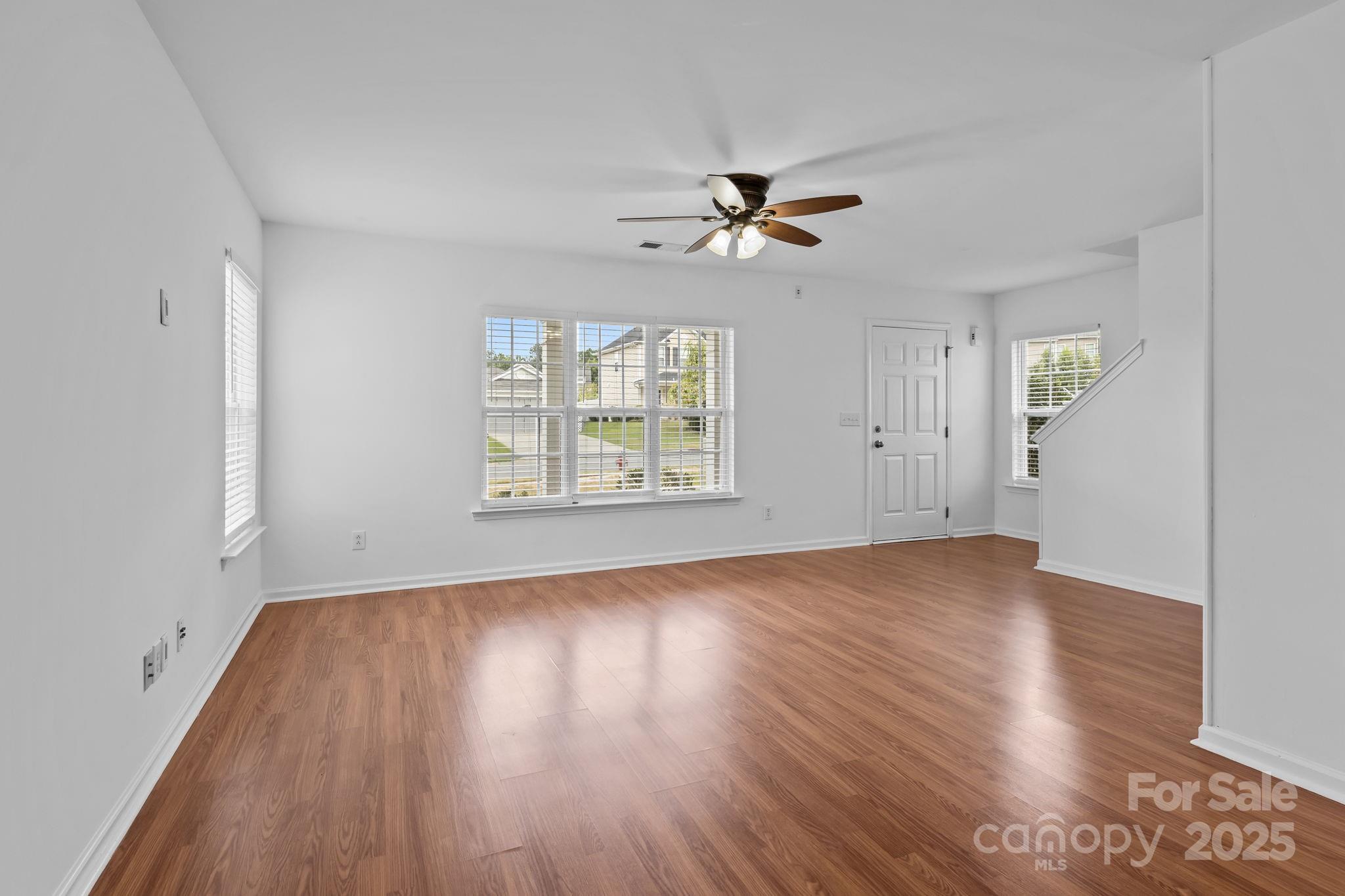 3425 Market View Drive Davidson, NC 28036 - Photo 9 of 23 an empty room with wooden floor chandelier fan and windows