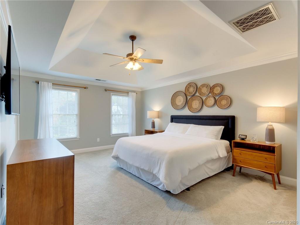 1612 Stevens Ridge Road Matthews, NC 28105 - Photo 25 of 44 a bedroom with a bed and a chandelier