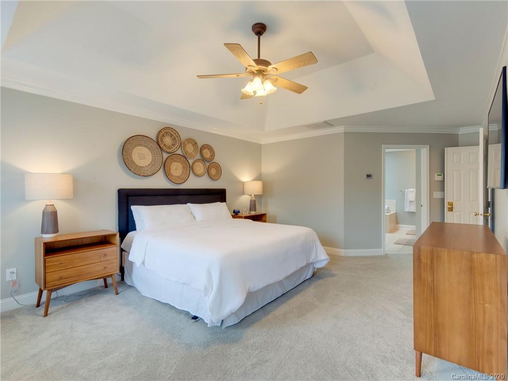 1612 Stevens Ridge Road Matthews, NC 28105 - Photo 26 of 44 a bedroom with a bed and a chandelier