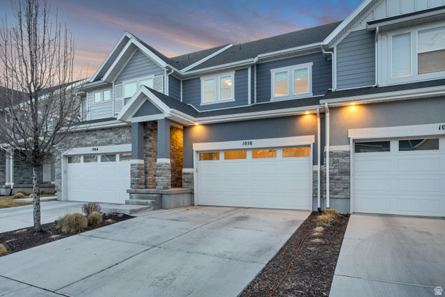 1058 Lilac Way Mapleton, UT 84664 - Photo 26 of 28 View of front of house with stone siding, driveway, a garage, and a shingled roof