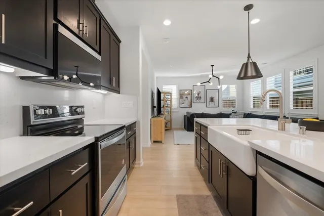 a kitchen with stainless steel appliances a sink a stove and a wooden floors