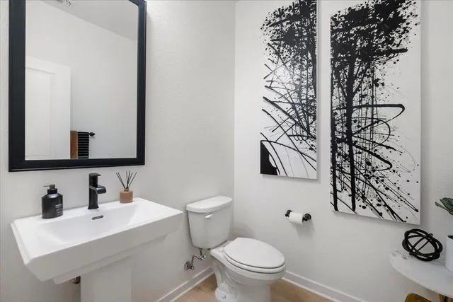 a bathroom with a sink toilet and mirror