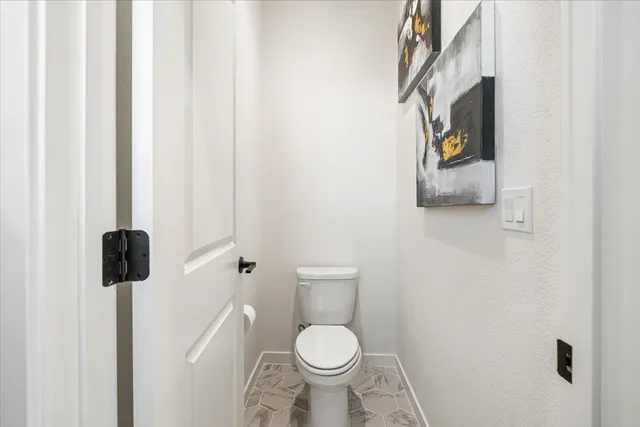 a white toilet sitting next to a shower