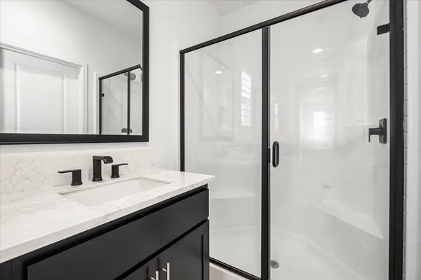 a bathroom with a shower sink and mirror