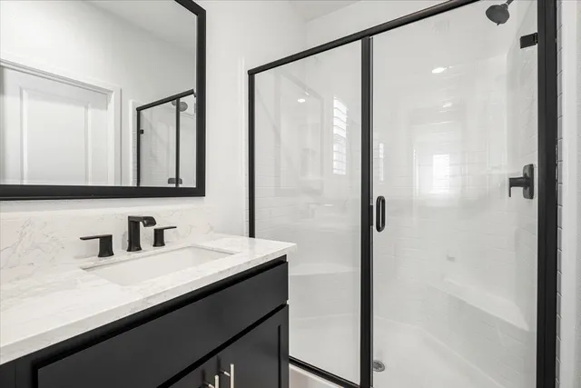 a bathroom with a shower sink and mirror