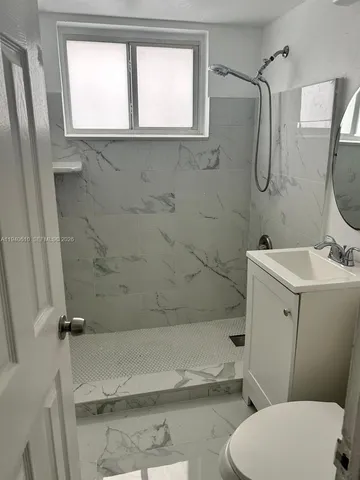 a bathroom with a sink a toilet and a mirror