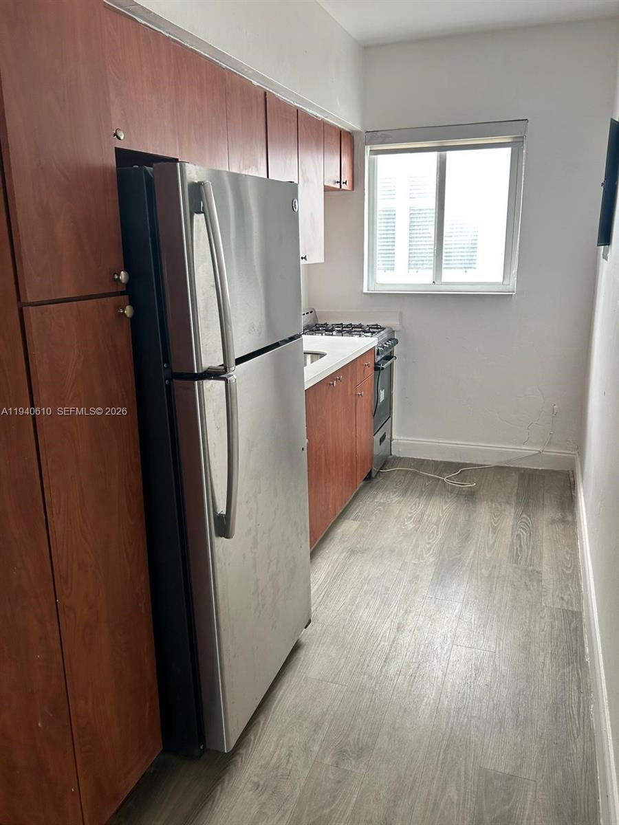 7330 Harding Avenue, Unit 4 Miami Beach, FL 33141 - Photo 2 of 5 a kitchen with stainless steel appliances a refrigerator and a wooden floor