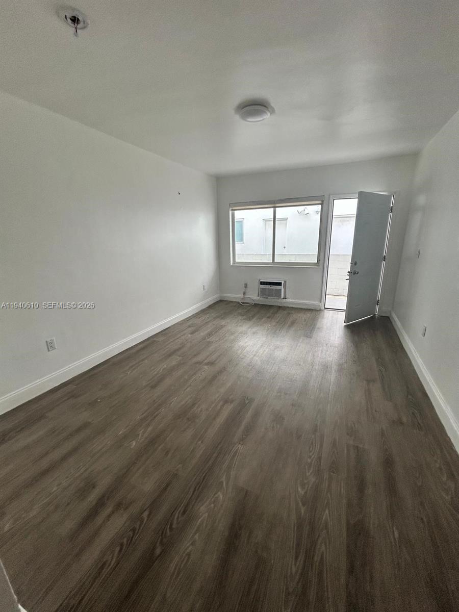 7330 Harding Avenue, Unit 4 Miami Beach, FL 33141 - Photo 3 of 5 an empty room with wooden floor and windows