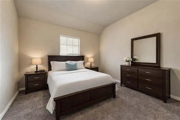 a bedroom with a bed and a mirror on dresser