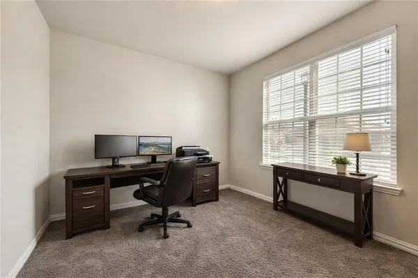 a view of a workspace with furniture and a window