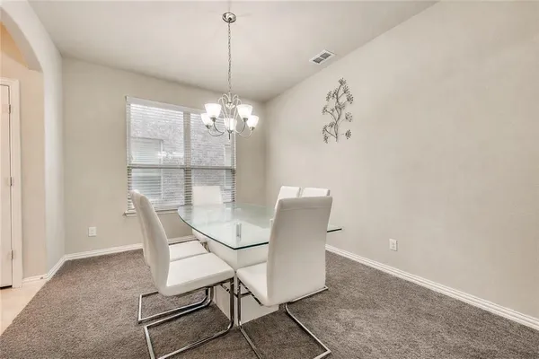 a view of a dining room with furniture and chandelier