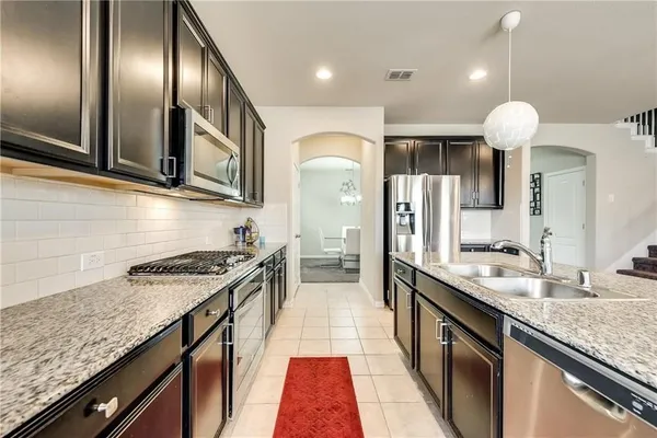 a kitchen with stainless steel appliances granite countertop a sink and stove