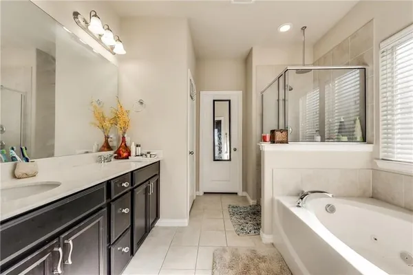 a bathroom with a tub a sink and mirror