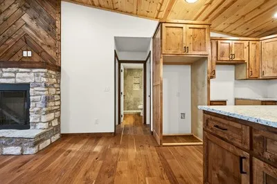 a view of a kitchen with wooden floor and a fireplace