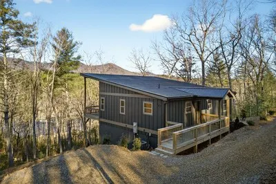 a view of a house with a yard and wooden fence