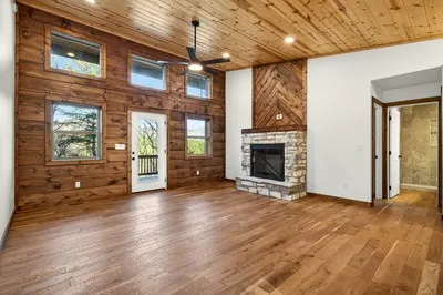 a view of an empty room with window and wooden floor