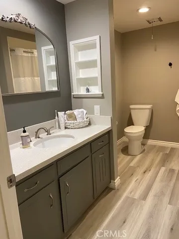 a bathroom with a double vanity sink toilet and a mirror