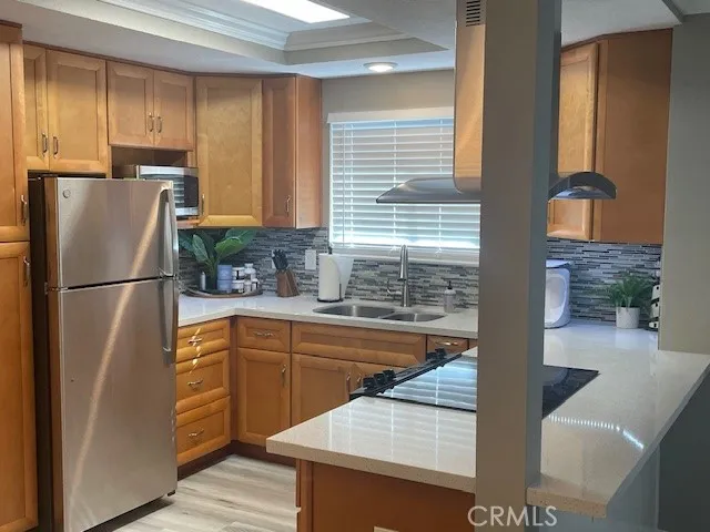 a kitchen with stainless steel appliances granite countertop a refrigerator a sink and a stove