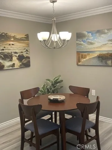 a view of a dining room with furniture a chandelier and wooden floor