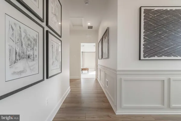 a view of a hallway with wooden floor and staircase