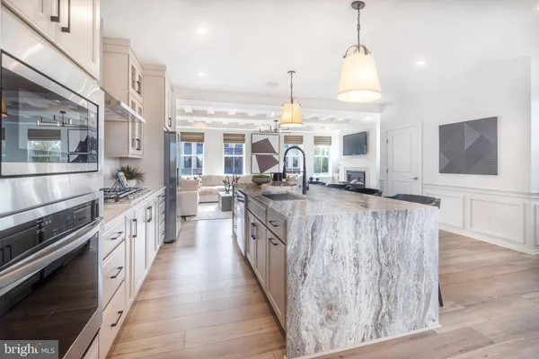 a kitchen with stainless steel appliances granite countertop lots of counter top space and wooden floor