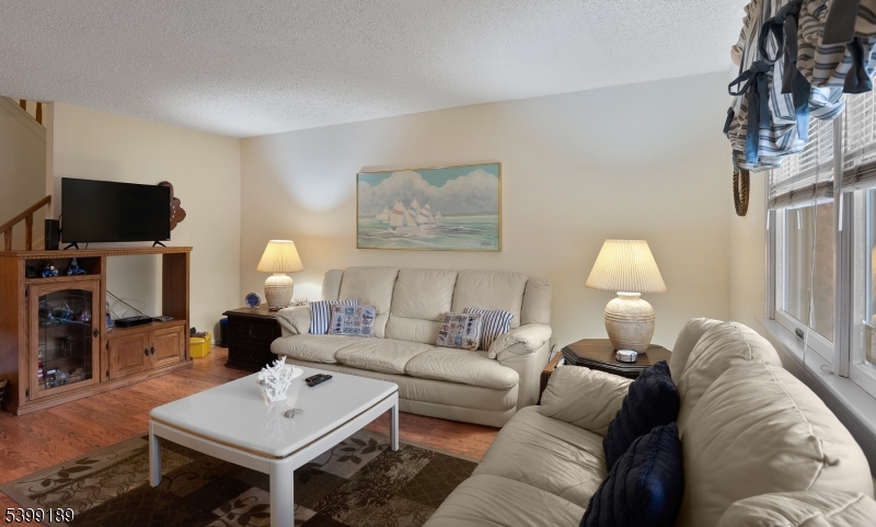 111 K Street, Unit A2 Seaside Park, NJ 08752 - Photo 5 of 15 a living room with furniture a flat screen tv and a fireplace