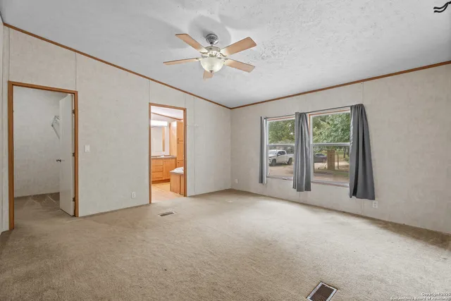 an empty room with fan and windows