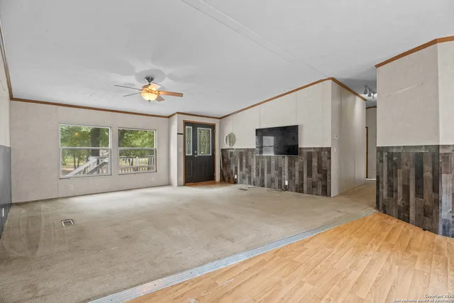 a view of a livingroom with wooden floor and a flat screen tv