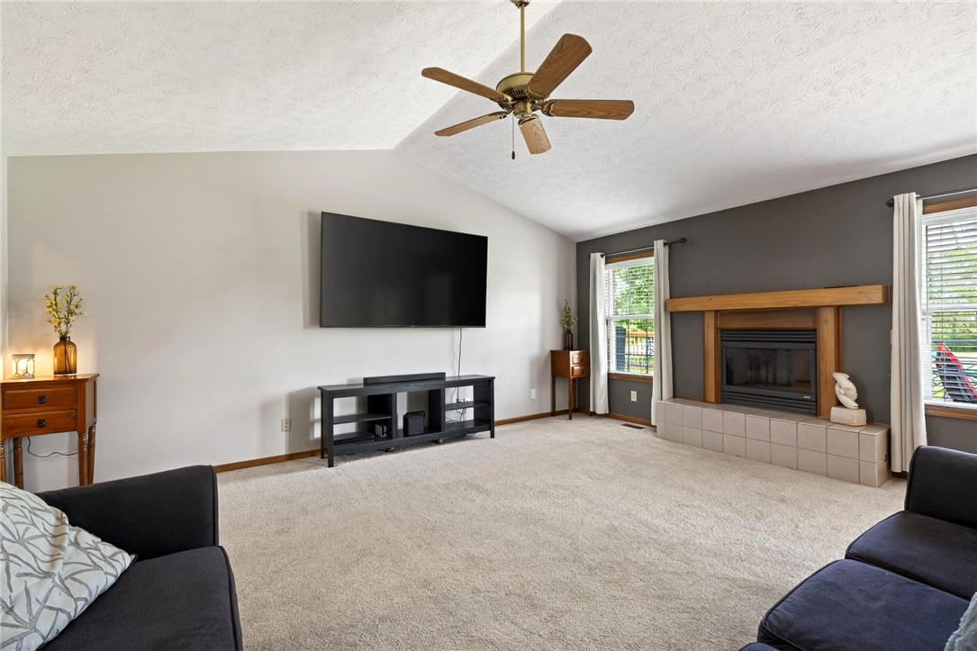 4996 Shannon Avenue Springfield, OH 45504 - Photo 21 of 61 This inviting living area features a cozy fireplace, vaulted ceilings, and soft carpeting.
